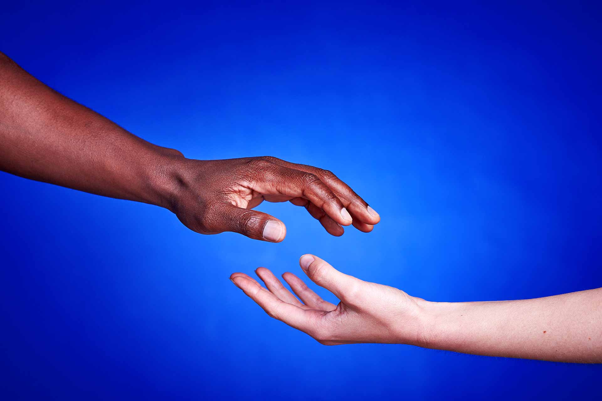 Black and white hands together against racism