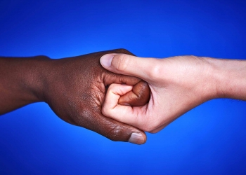 Black and white hands together against racism