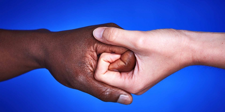 Black and white hands together against racism