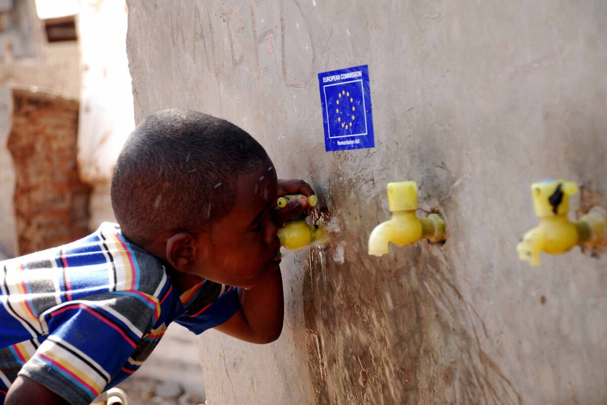 A young Somali refugee drinks water from a public tap provided by EC Humanitarian Aid