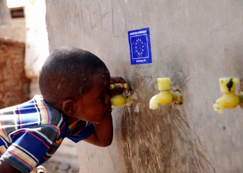 A young Somali refugee drinks water from a public tap provided by EC Humanitarian Aid