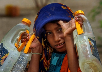 A young Yemeni fetches water at a makeshift camp