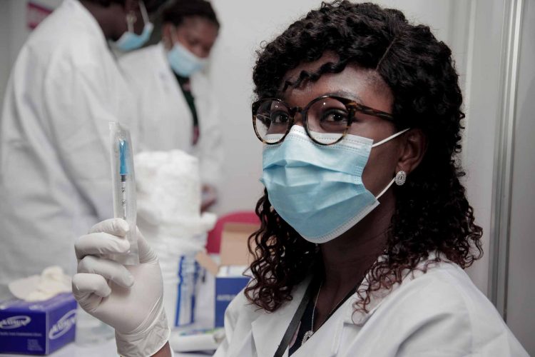 A nurse holding a syringe donated by COVAX